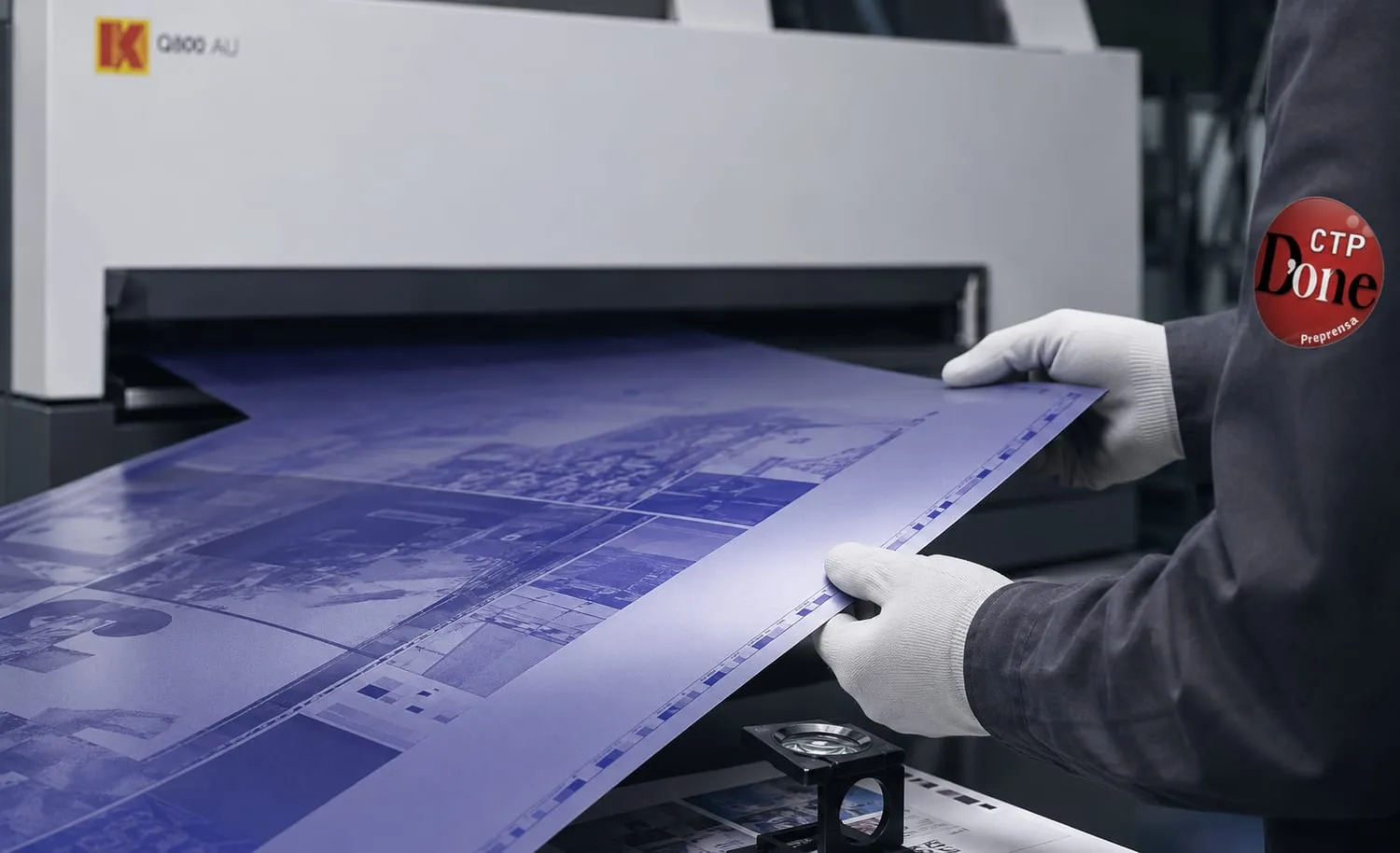 Operario de CTP D'one revisando una placa CTP recién filmada
